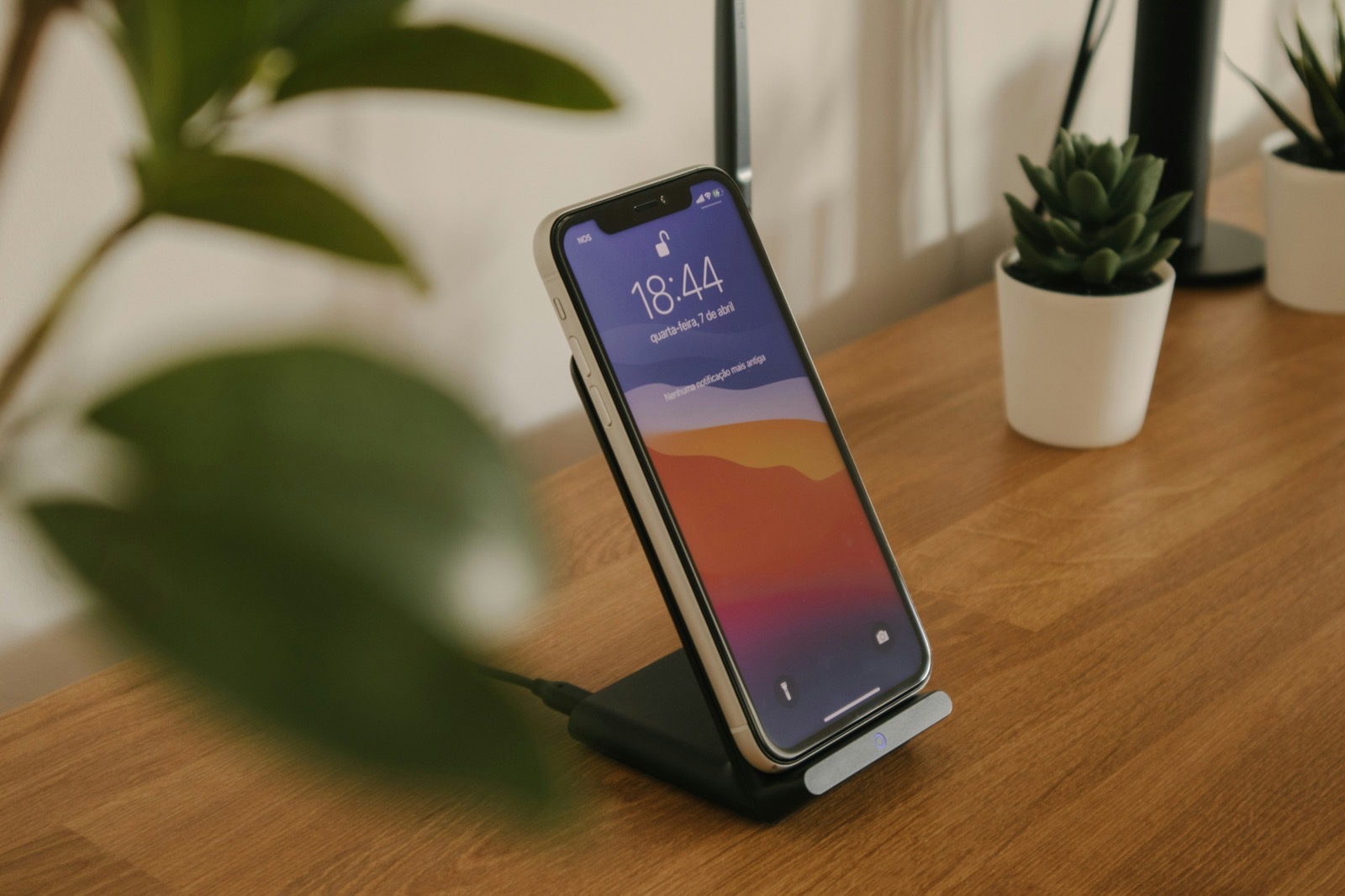 A black Android smartphone resting alone on a wooden desk, with no laptop in sight