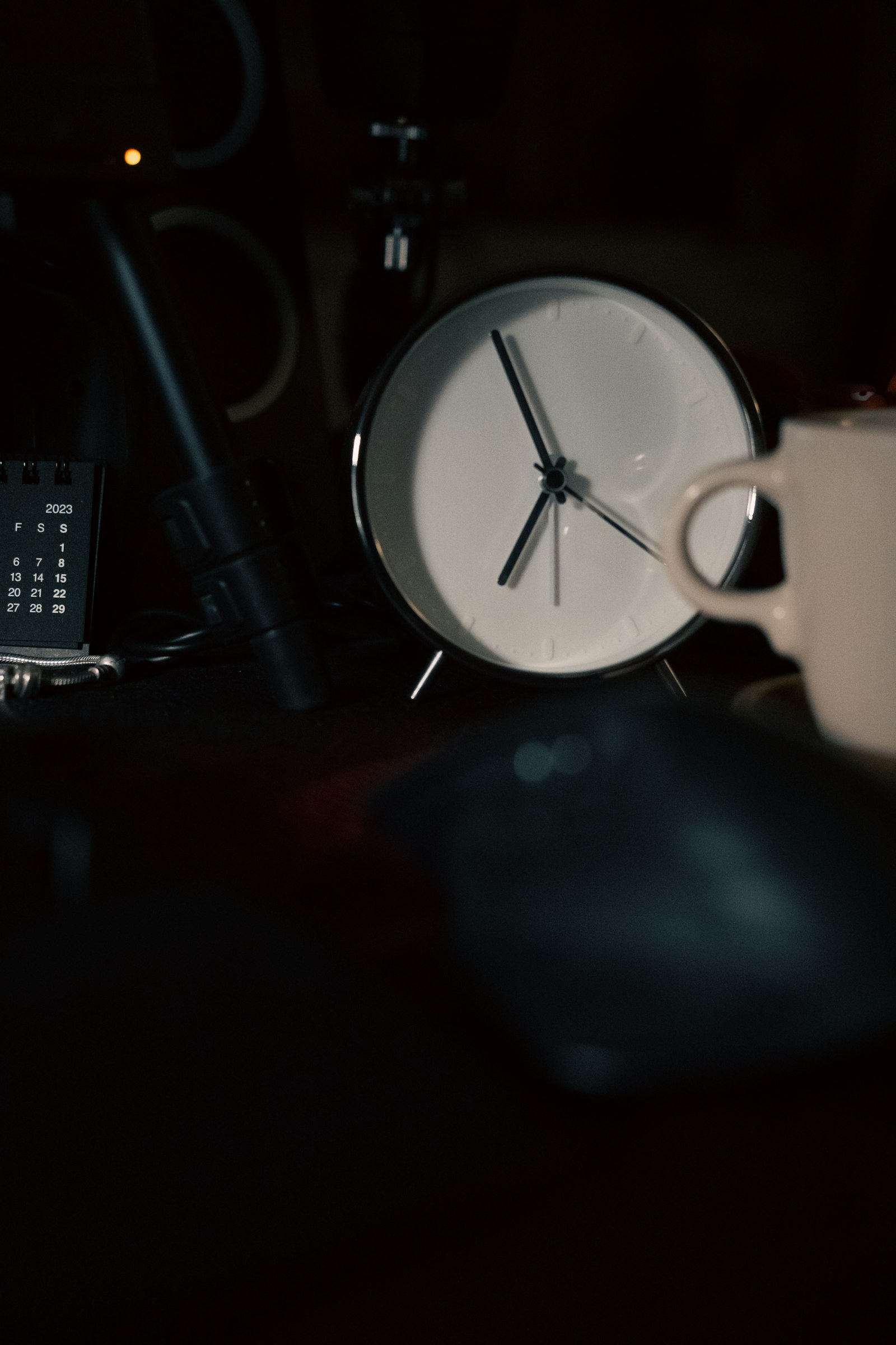 A clock sitting on a desk next to an open laptop, evoking pacing and timing in a video edit