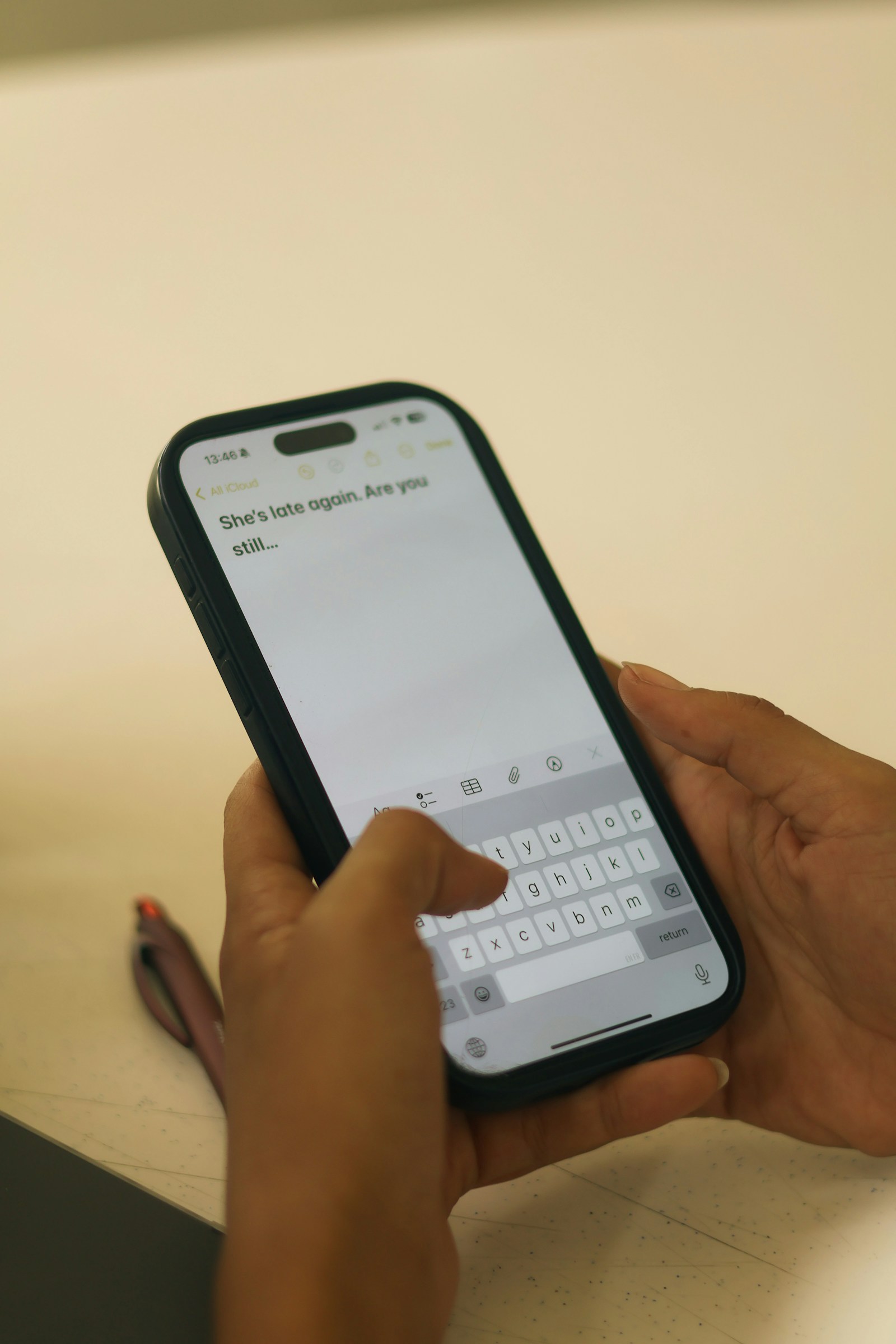 Close-up of hands typing a message on a smartphone screen